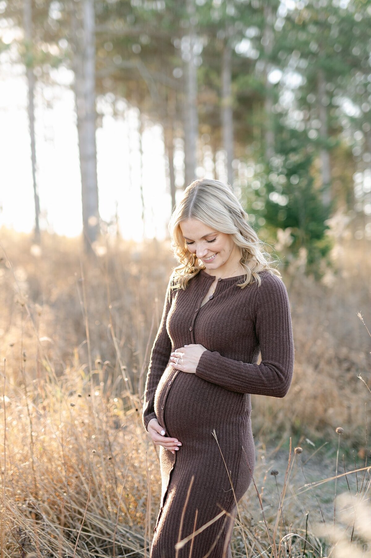 Expecting mother smiling at her pregnant belly