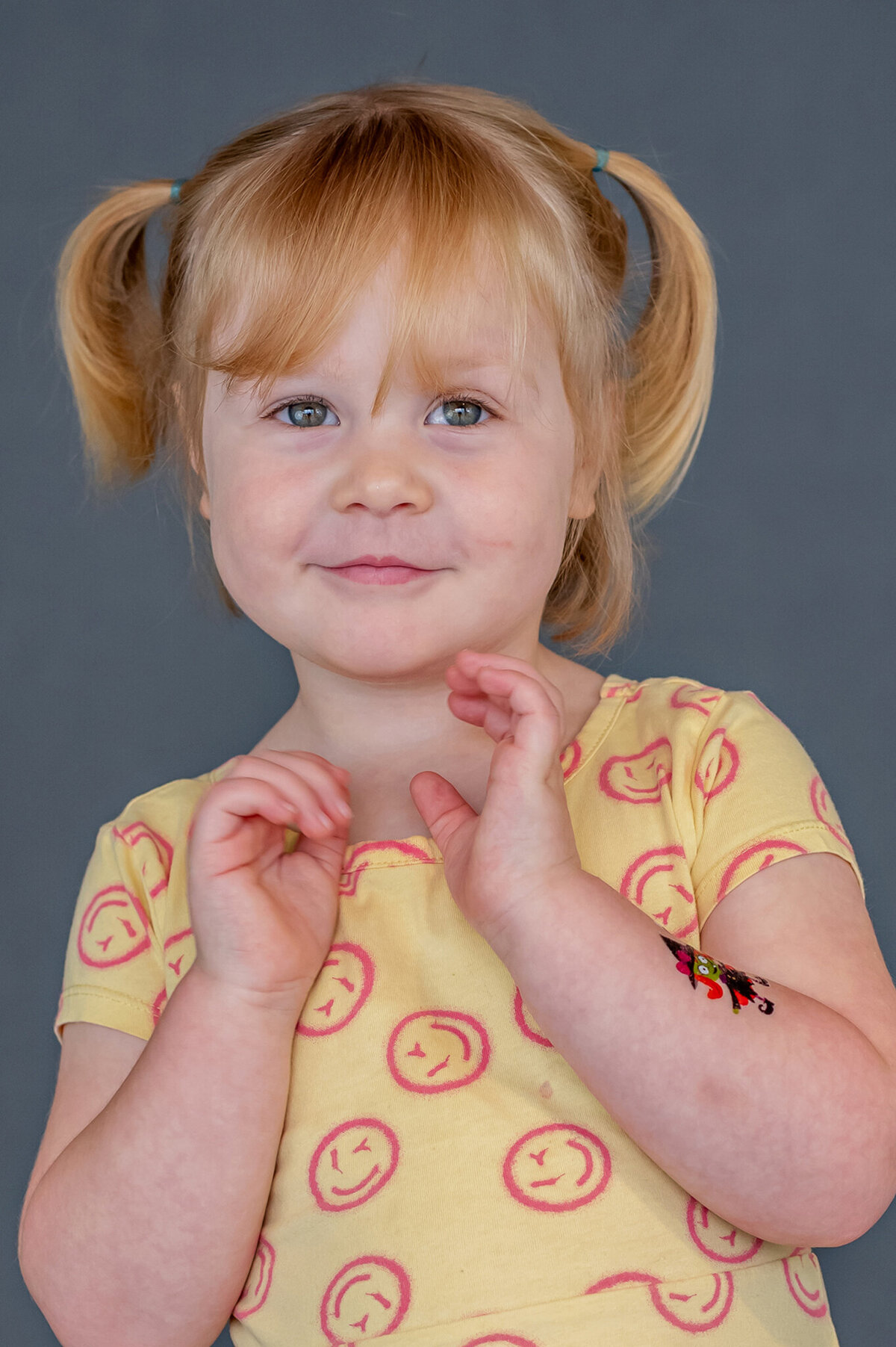 Blonde haired preschool girl is excited for her preschool portraits.