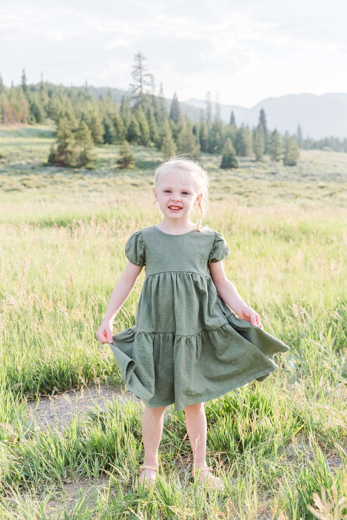 girl holding dress looking at camera colorado fields