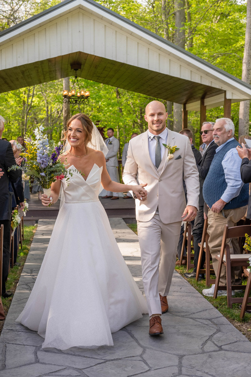 Bride and groom walk up the aisle after their outdoor ceremony