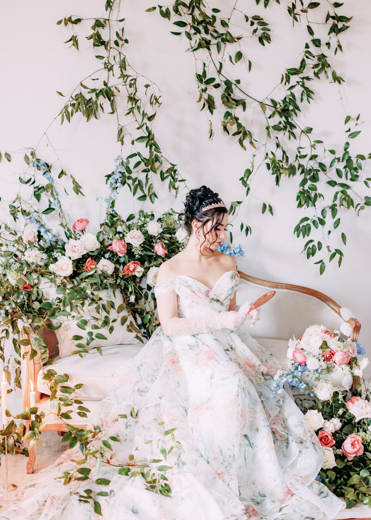 bride on love seat surrounded by florals