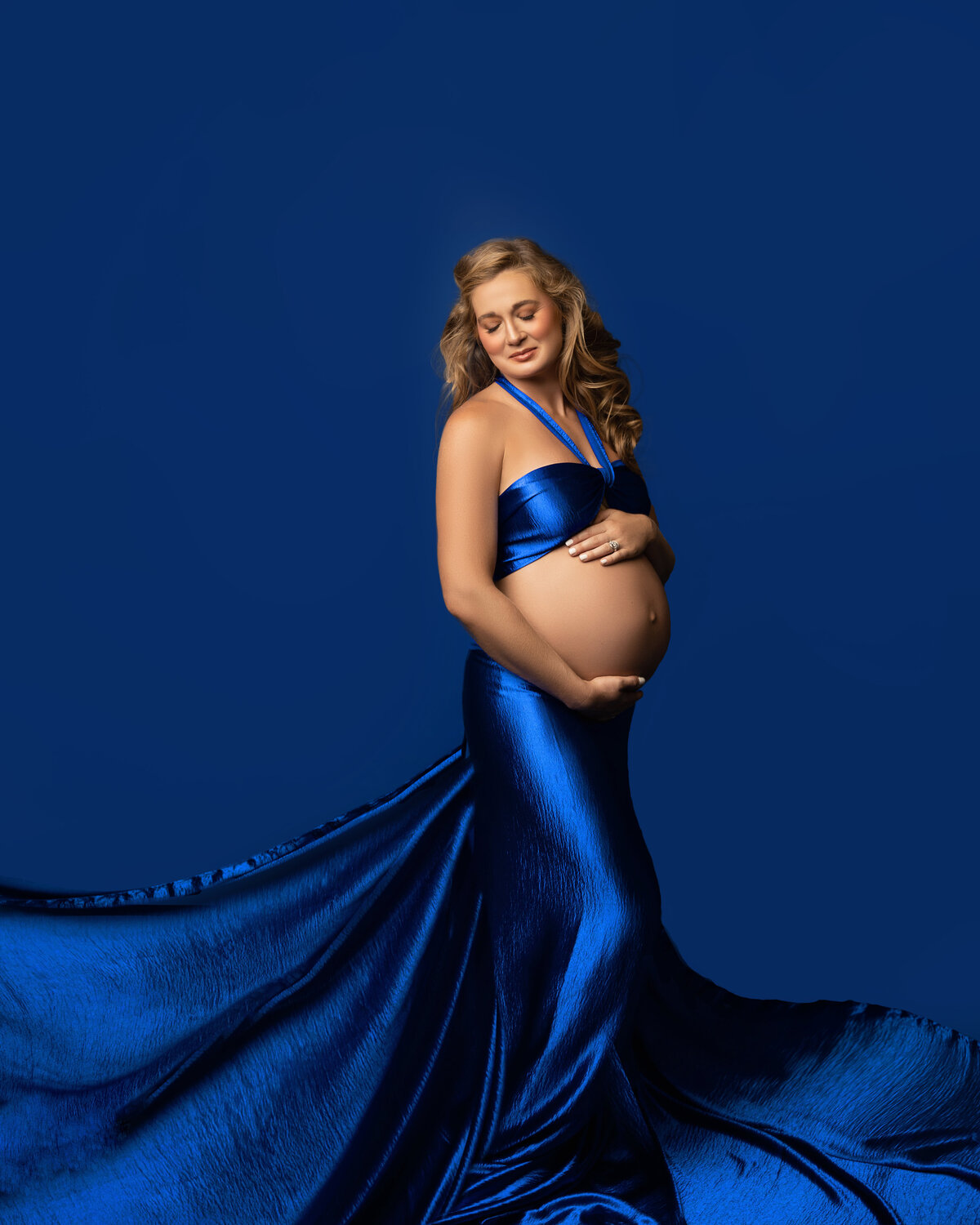 flowing fabric blue pregnant exposed belly studio woman blonde
