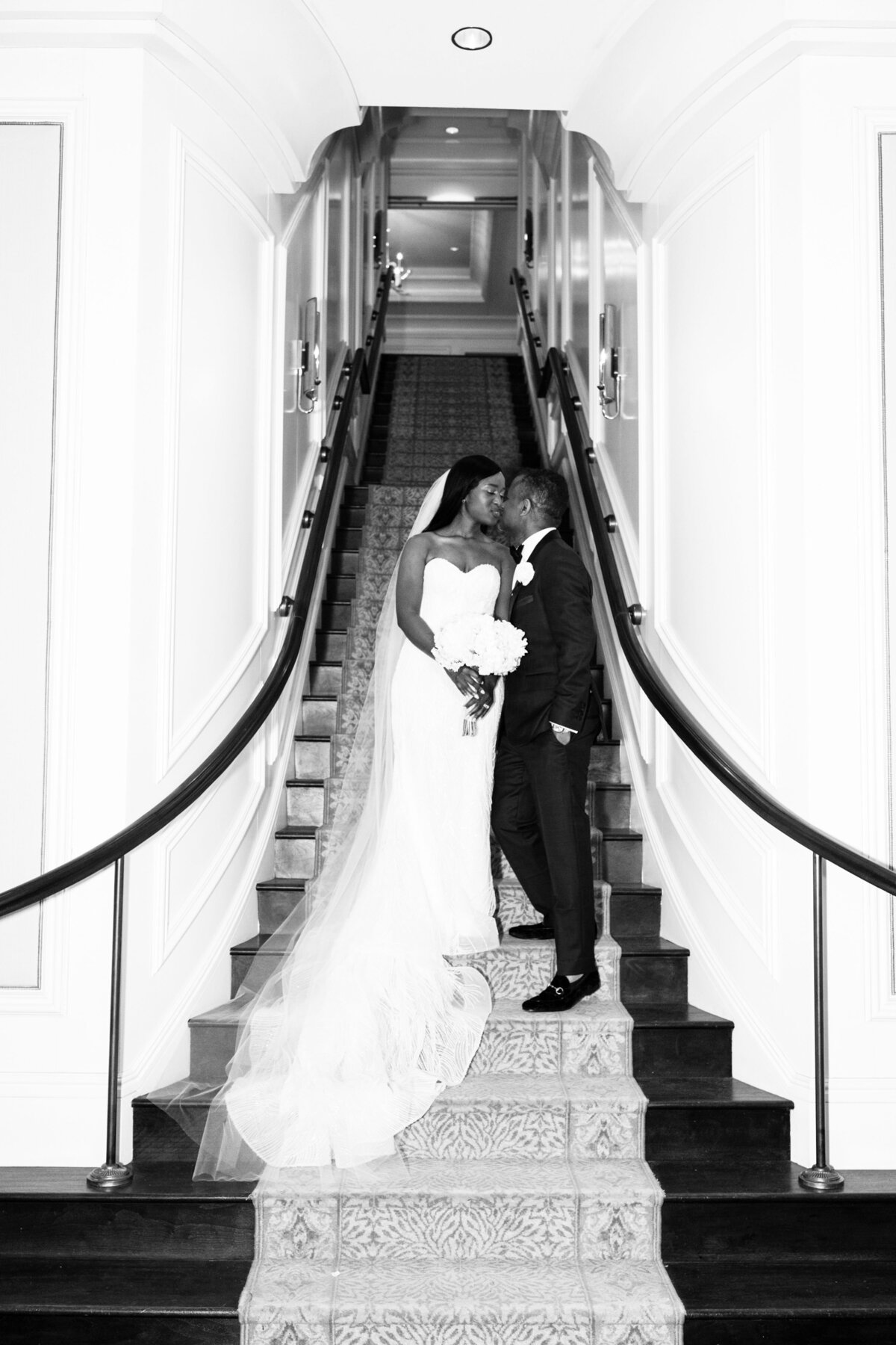 st-regis-atlanta-wedding-black-and-white-staircase-kiss