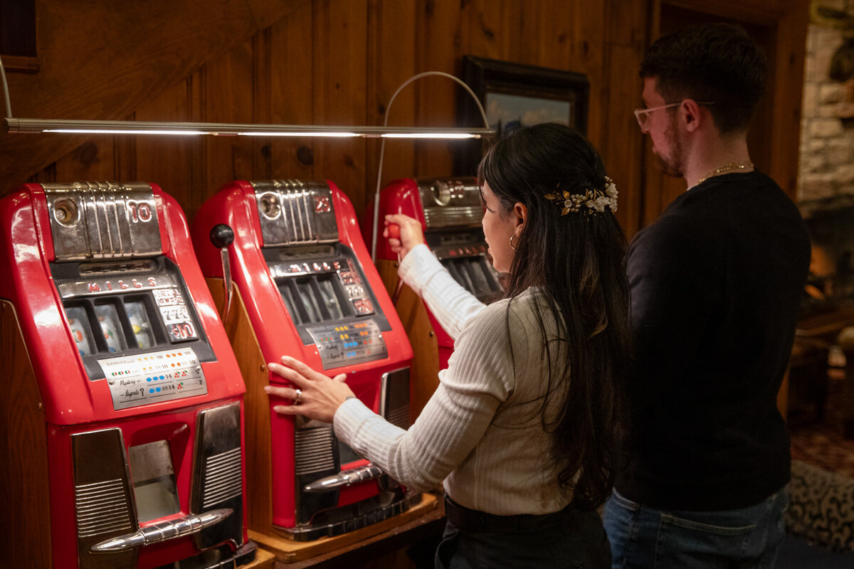 A bride and groom play the slot machine at an old casino in Wyoming.