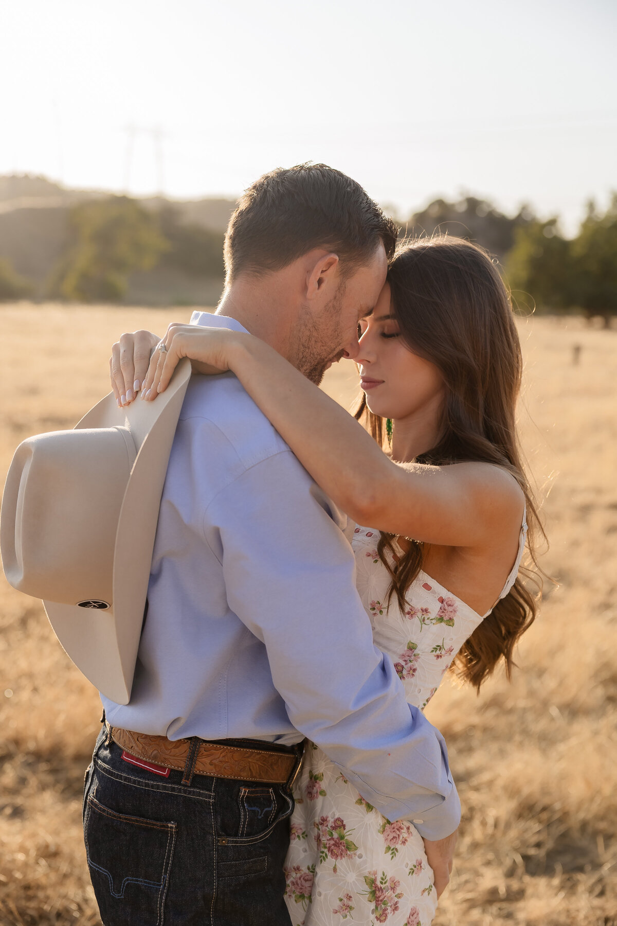 candid couples engagement photos in open field during golden hours in San Luis Obispo