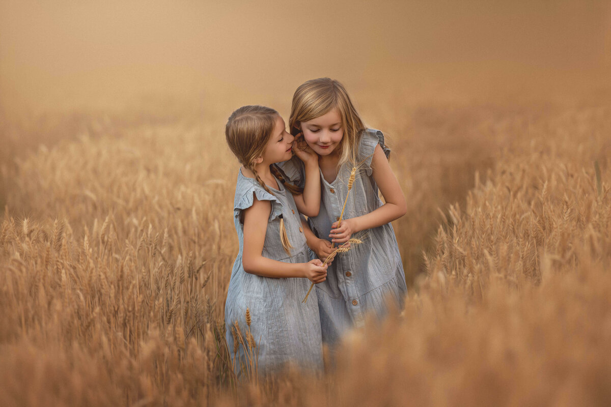 Sisters in a wheat field whispering