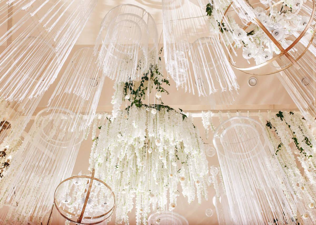 Hanging wedding decor made of white ribbons on hoops to create a stunning centrepiece at a high-end luxury part.