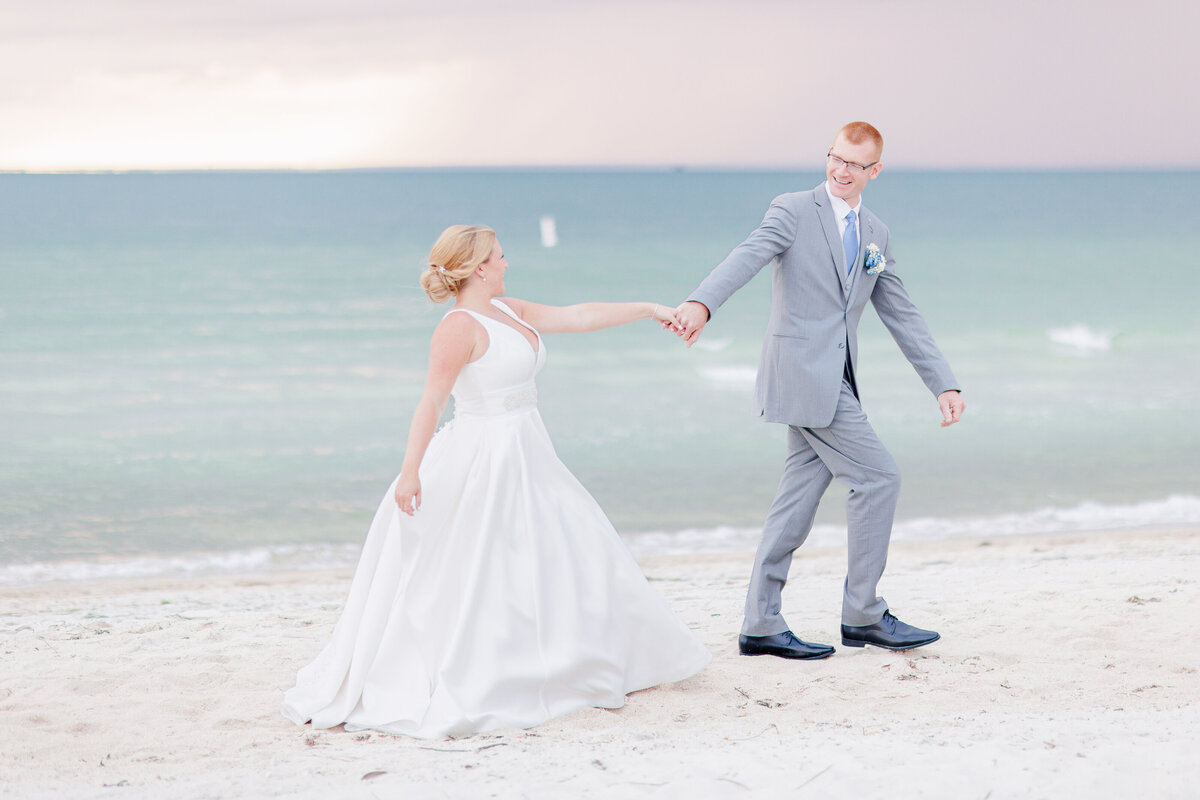 Groom leading his bride down the beach representing romantic Cape Cod wedding photography