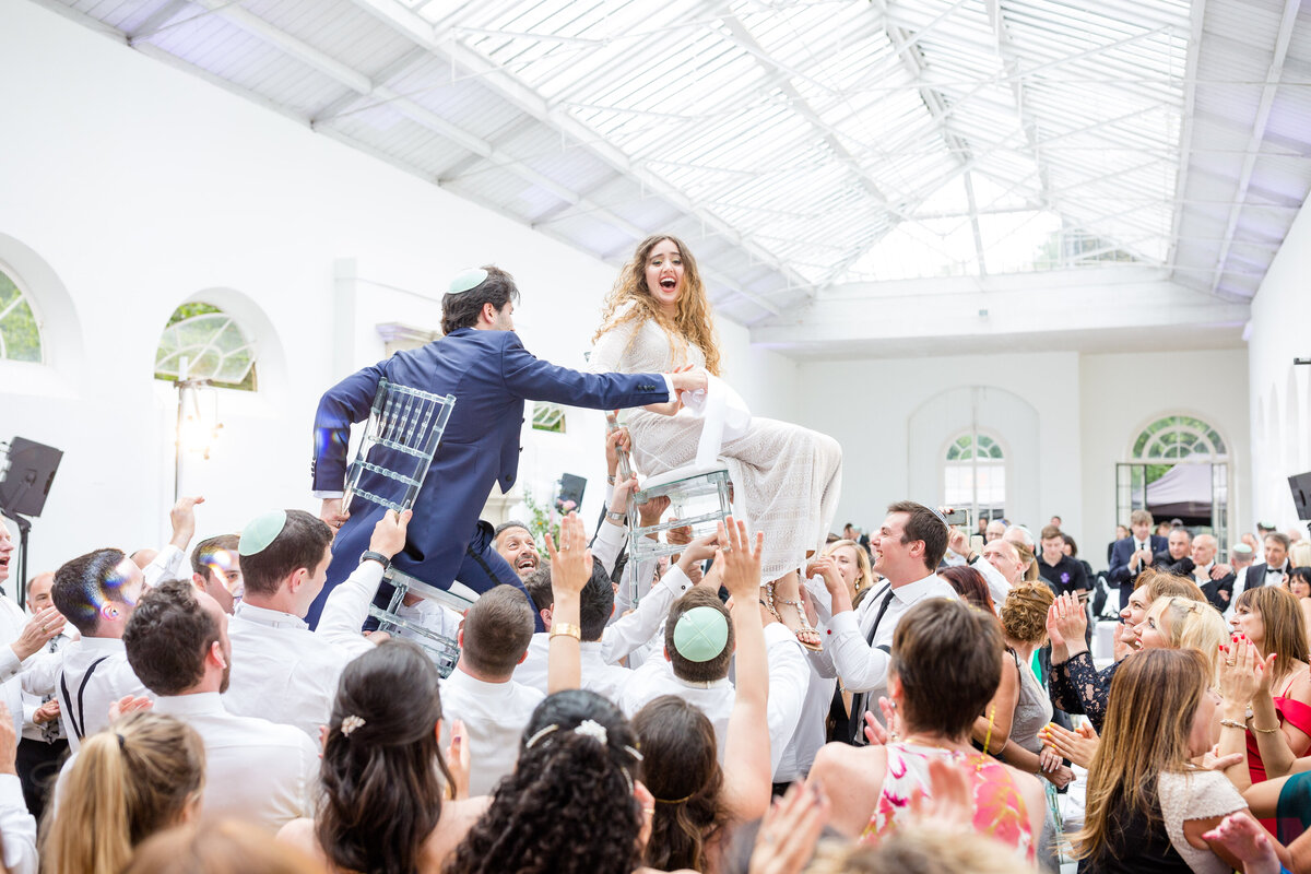 Bride and Groom lifted up on chairs during their wedding reception