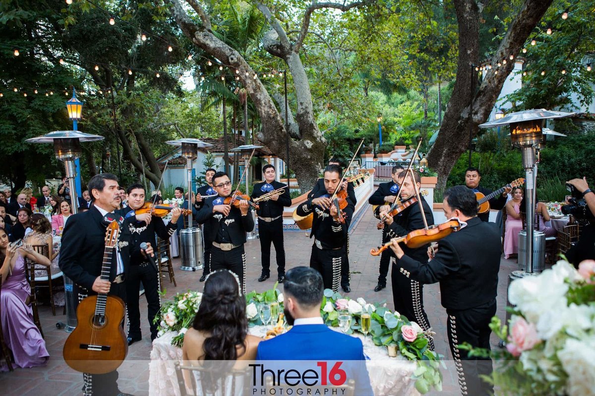 Mariachi Band performs at wedding reception as Bride and Groom look on