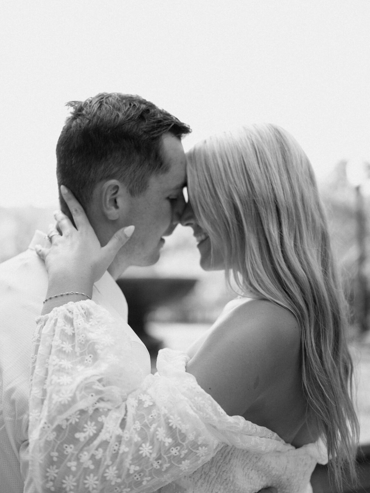 Black and white raw moment of couple almost kissing.