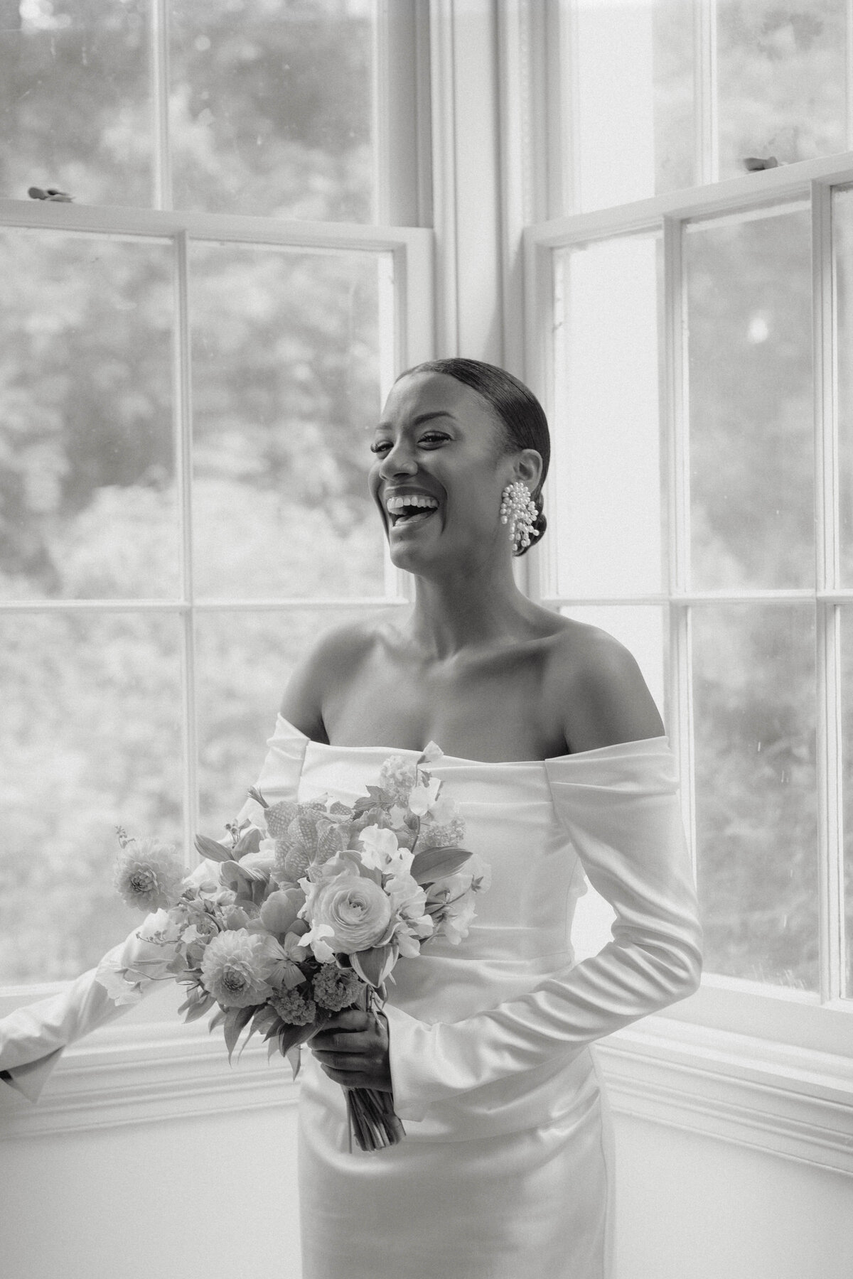 Cinematic wedding photography capturing a candid, joyful bride in elegant black and white, highlighting authentic beauty and emotion.