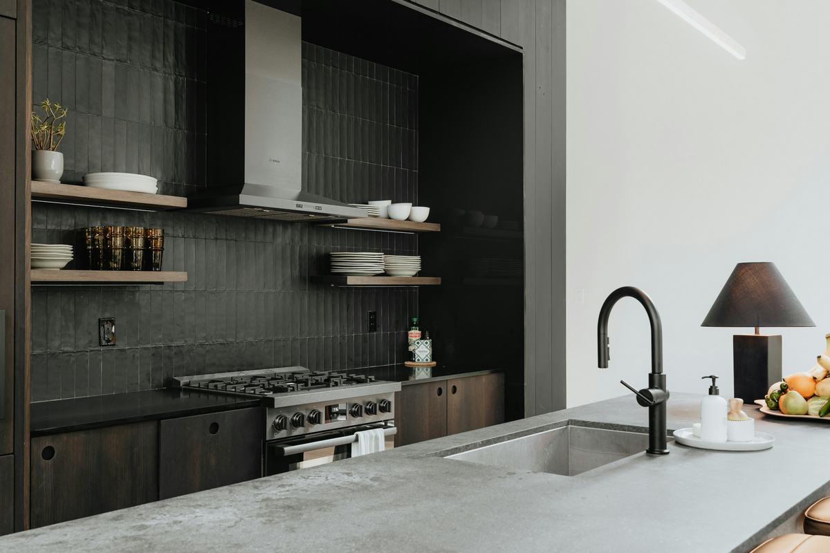 modern kitchen with black faucet and black tile backsplash