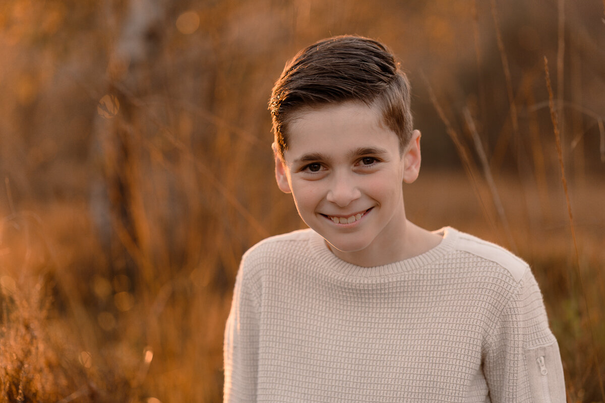 portret van een jongen met de ondergaande zon tijdens een gezinsshoot