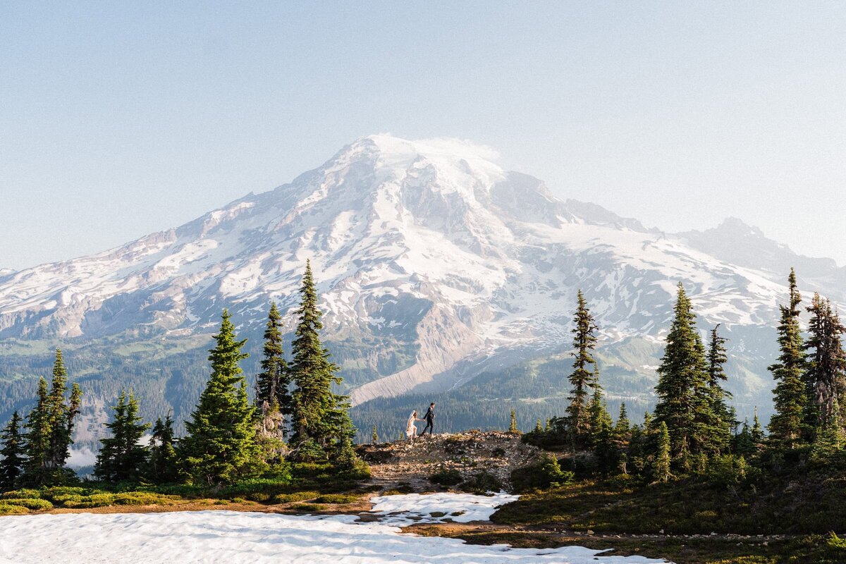 Sunrise elopement at Mount Rainier National Park. Couple Hiking in the distance.