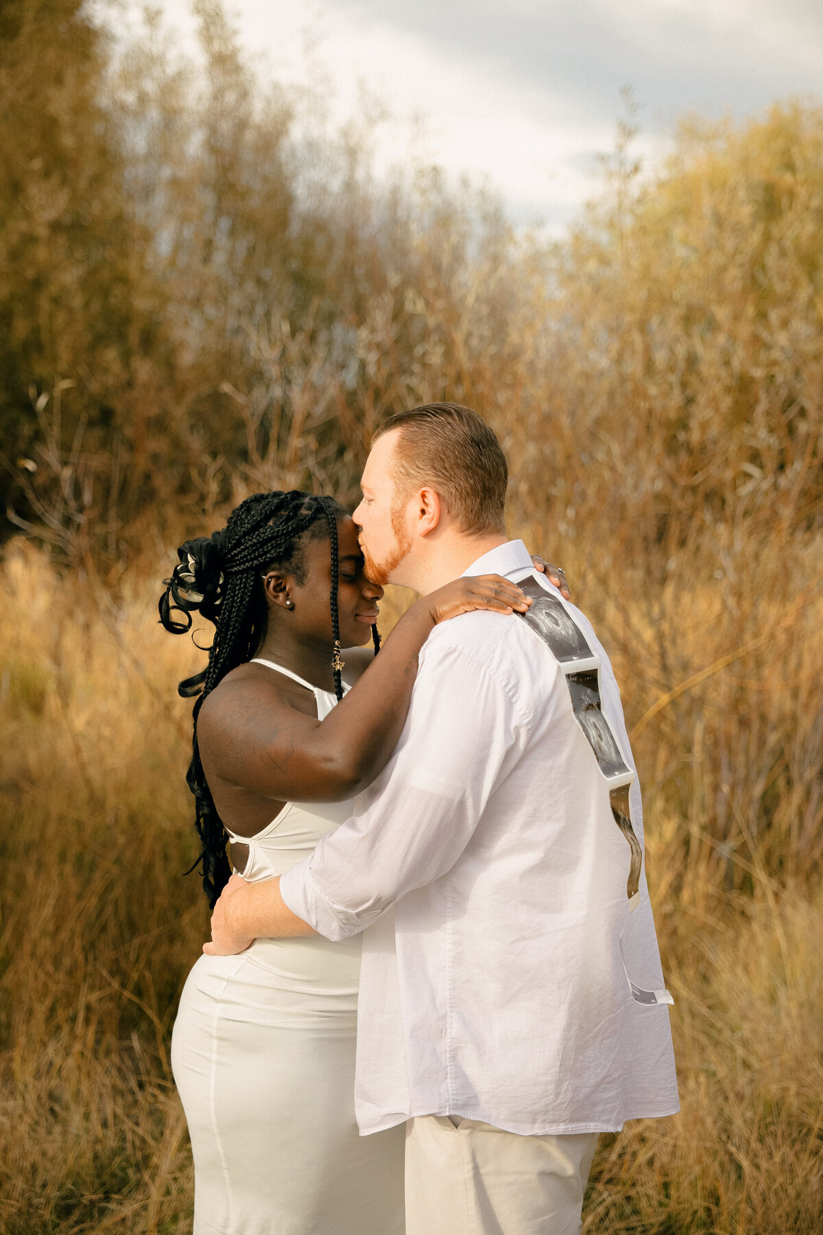 Emotional Maternity Couple Portrait with Ultrasound Photos on Back of Shirt