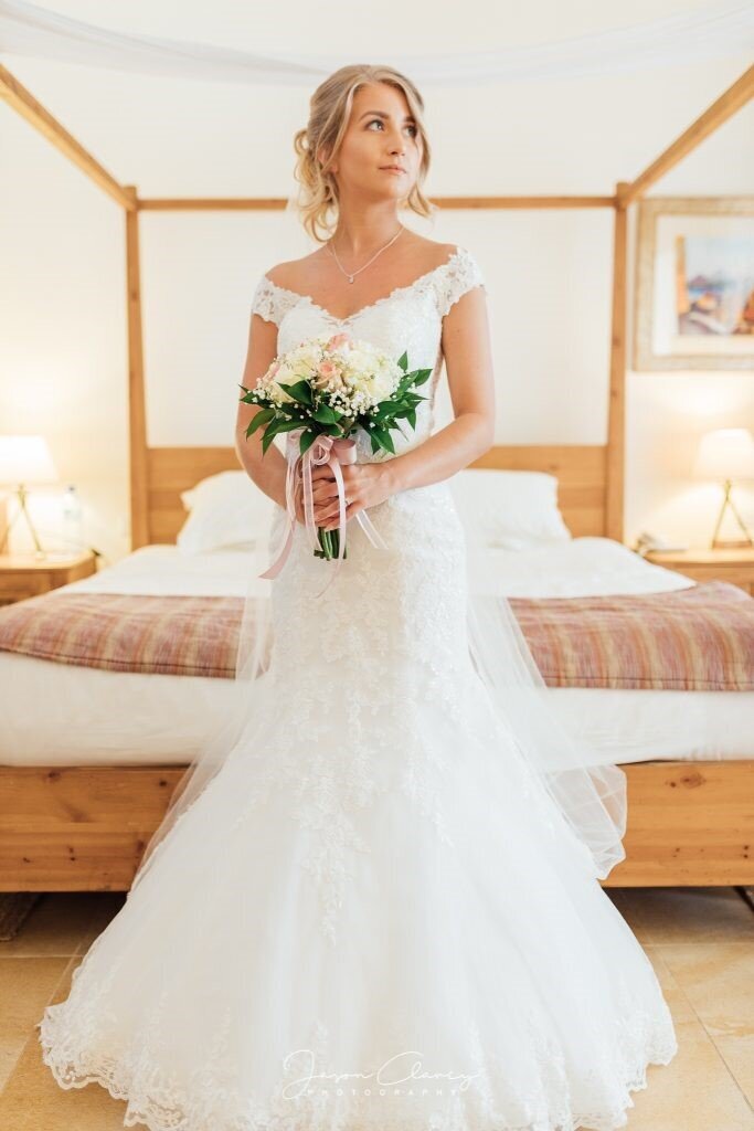 Bride wearing long white wedding dress holding  blush pink bouquet