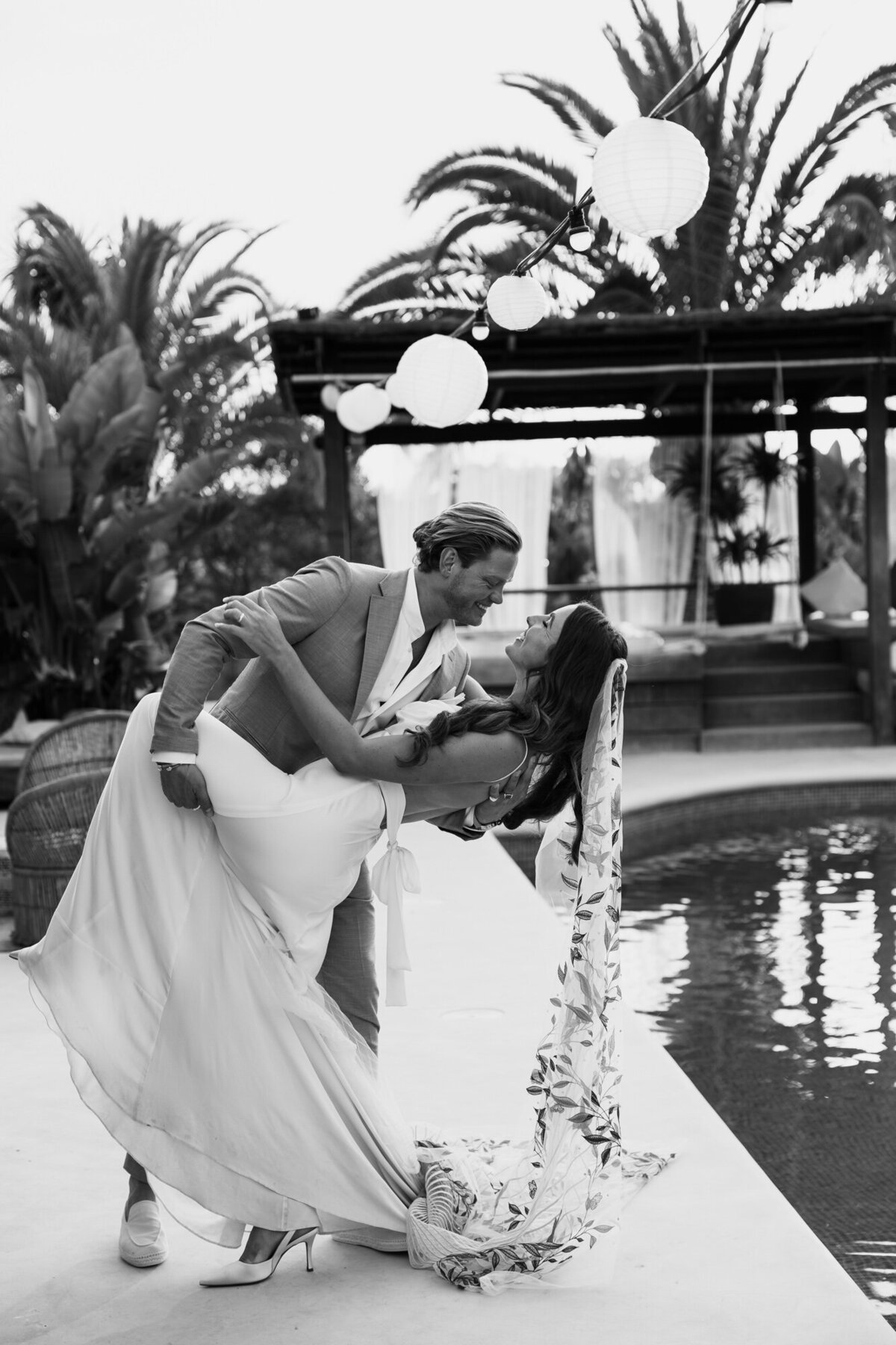 Husband and wife are doing a dip near the pool for their after wedding shoot during sunset on Ibiza