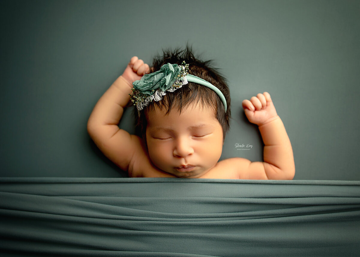 sleepy baby in a swing with floral background