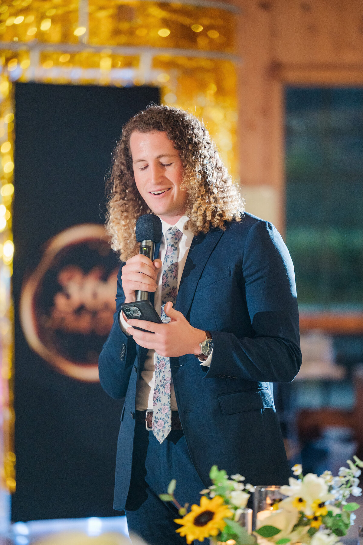 guest with long curly hair giving wedding speech at pennsylvania summer camp wedding