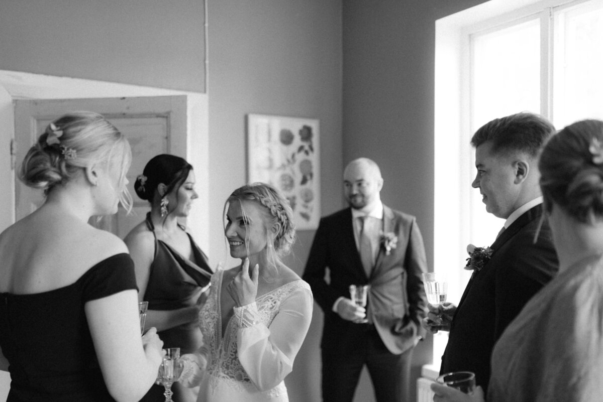 A documentary wedding  photo of the bride and groom with their entourage in Oitbacka gård captured by wedding photographer Hannika Gabrielsson in Finland