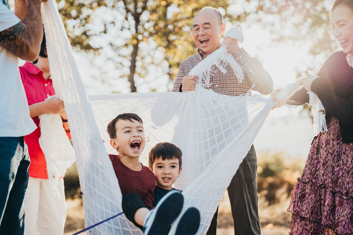 grandparents-laughing-with-grandsons-in-sunlight