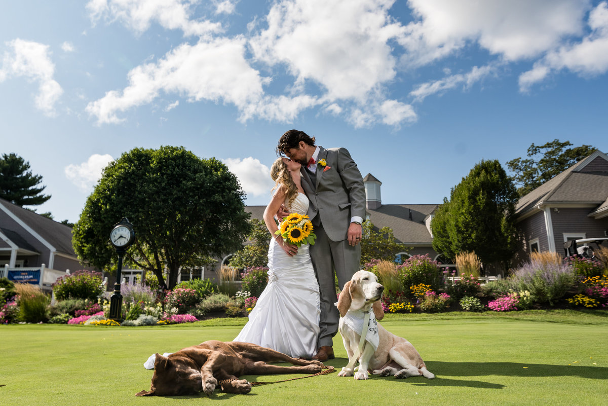 bride and groom posing with dogs in Golf Course