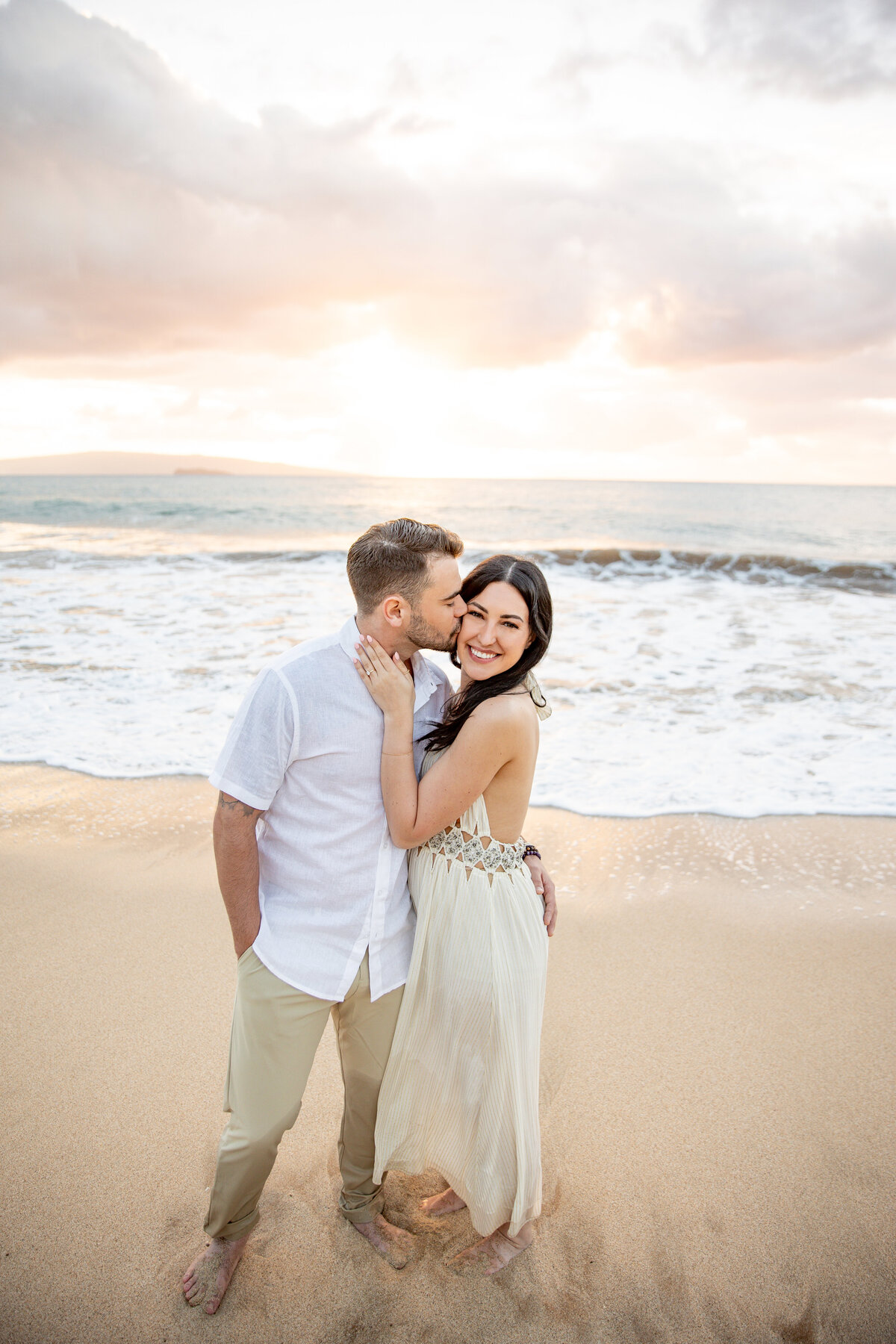 Maui Couples Photographer captures man kissing woman's cheek during beach engagement photos