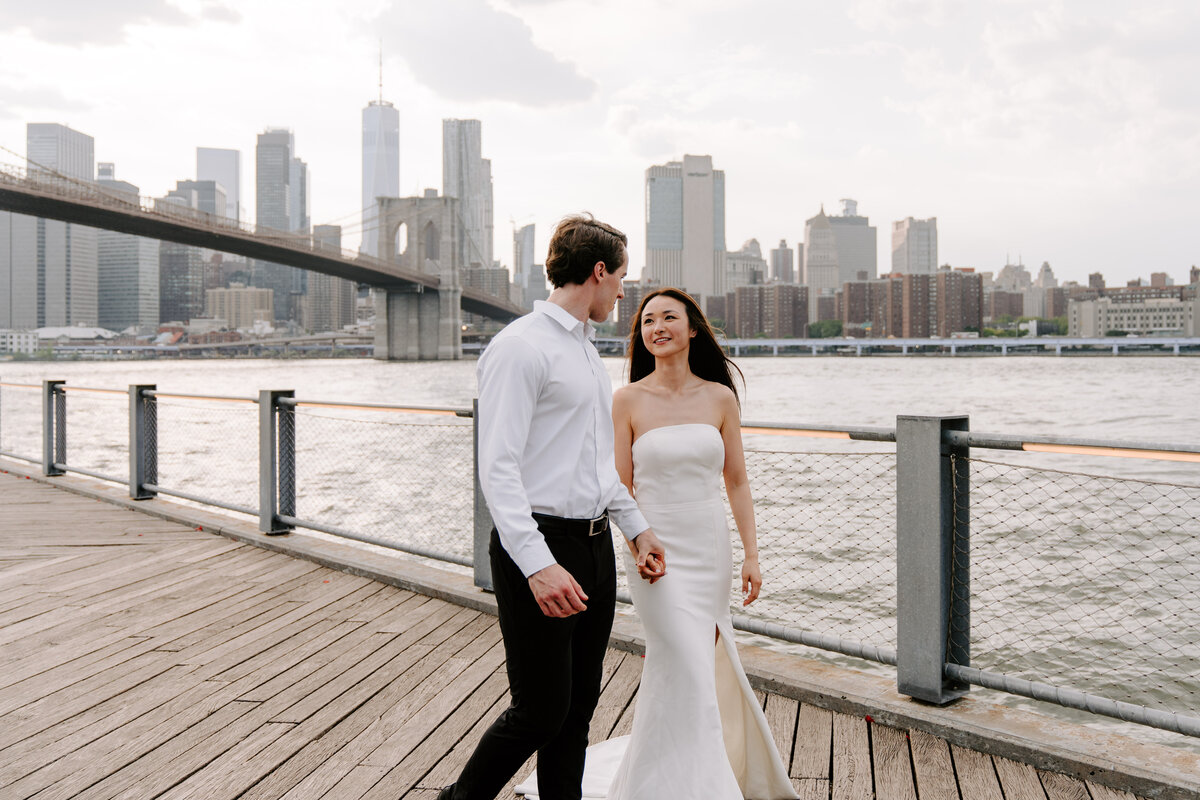 newlyweds pose silly on boardwalk