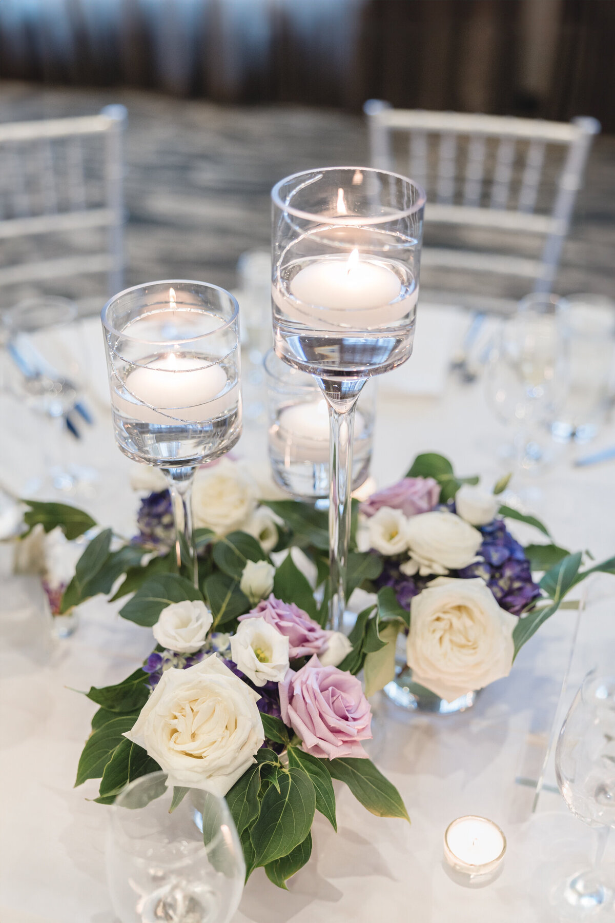 Purple and white flowers with glass candle sticks