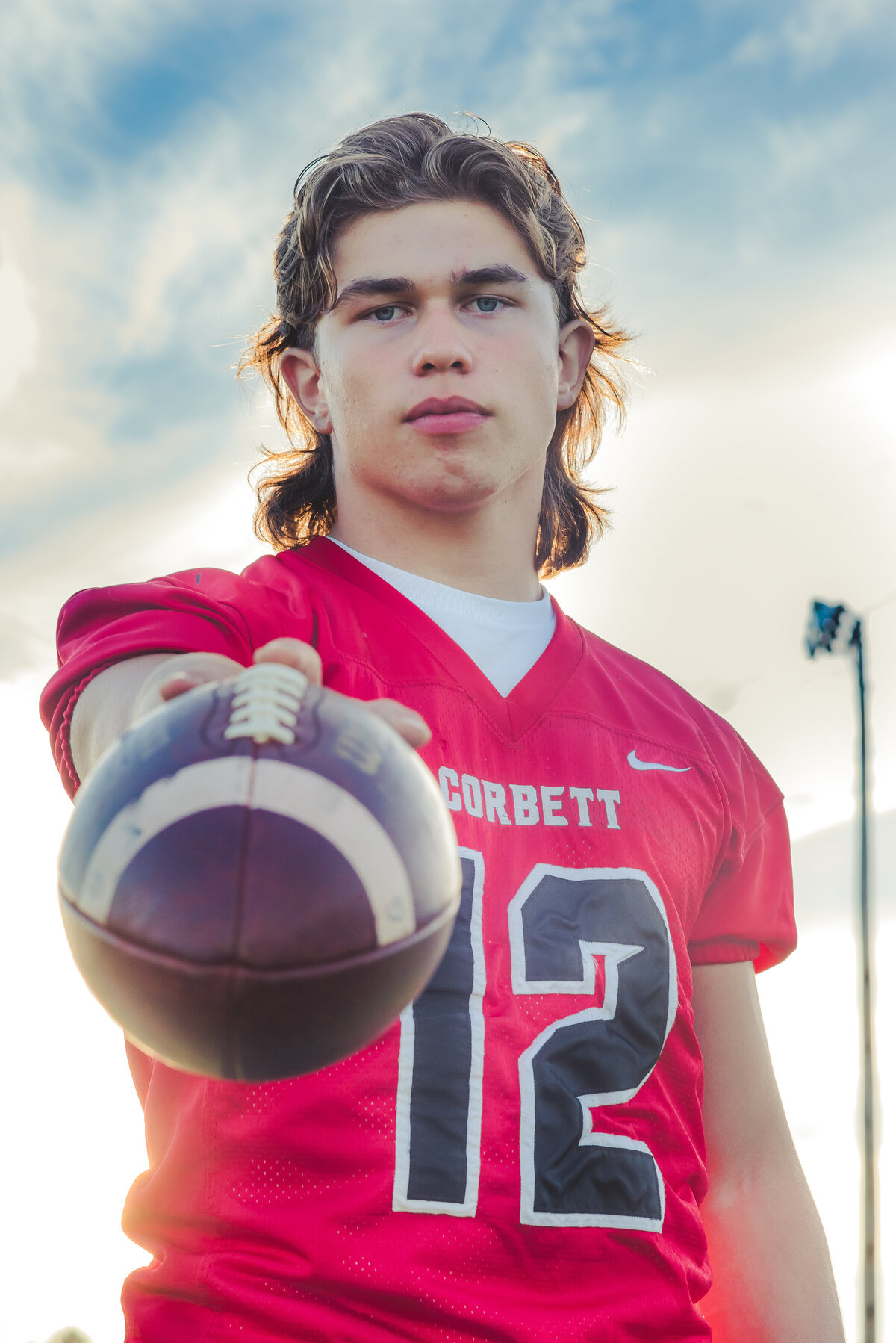 senior boy holding football