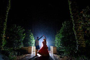 St Augustine wedding photographers capture romantic nighttime scene with couple dancing in rain under starlit sky surrounded by lush trees