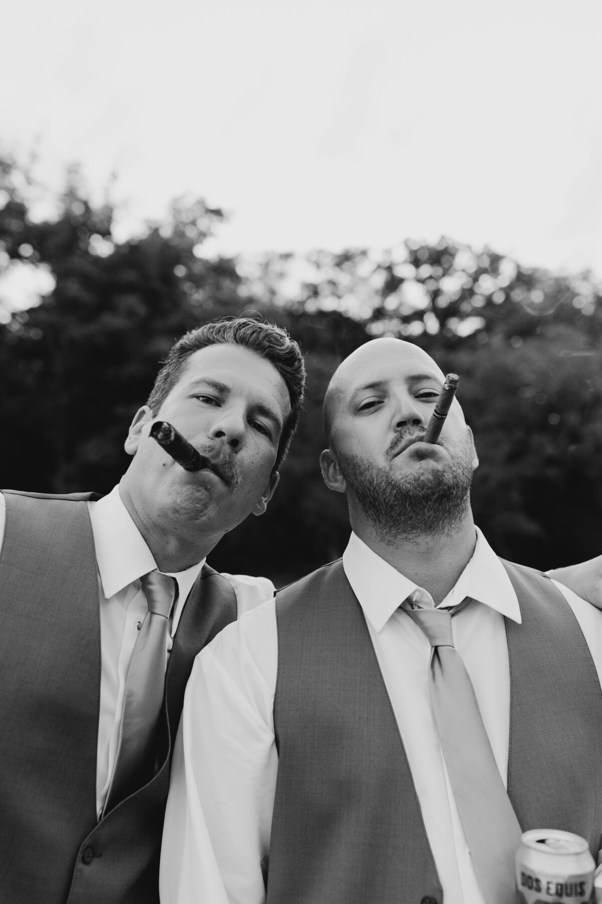 Groomsmen playfully posing with cigars in a candid moment during a South Bend wedding celebration.