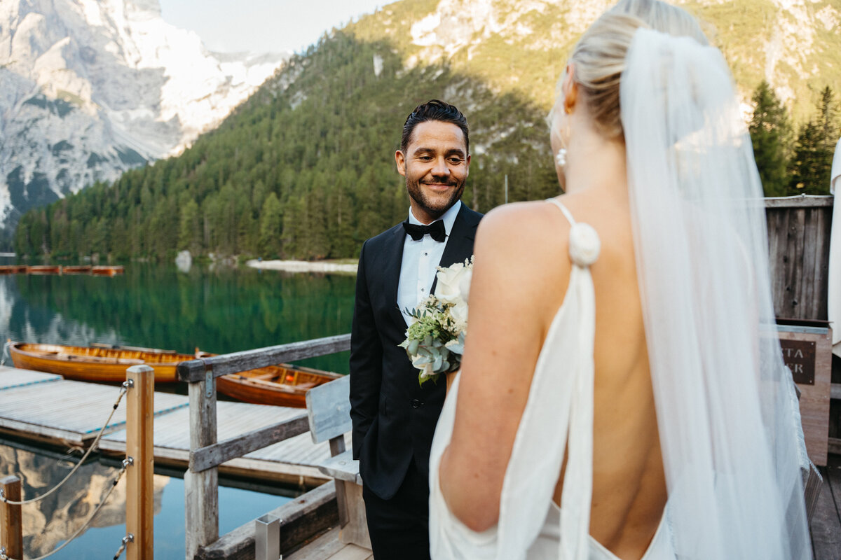 Bride and groom smiling during first look at Lago di Braies dock