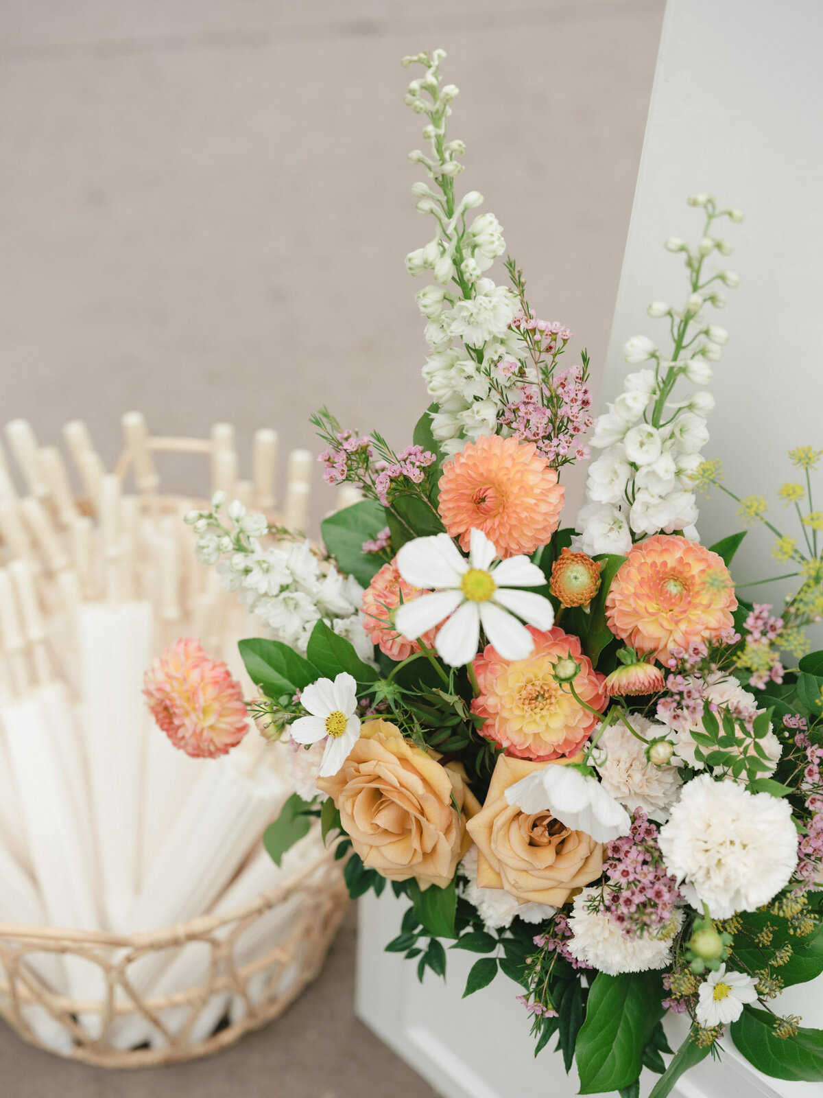 styled umbrella basket and florals in front of a custom calligraphy wedding welcome sign representing full service design and calligraphy by Life in Letters.