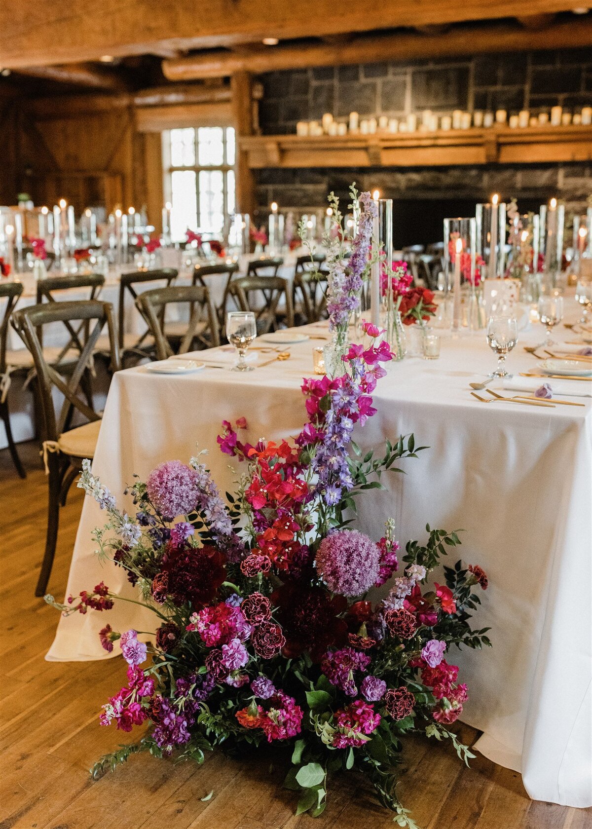 Purple flowers on the floor next to guest tables with bud vases and candles at the Great Hall in Sunriver Oregon