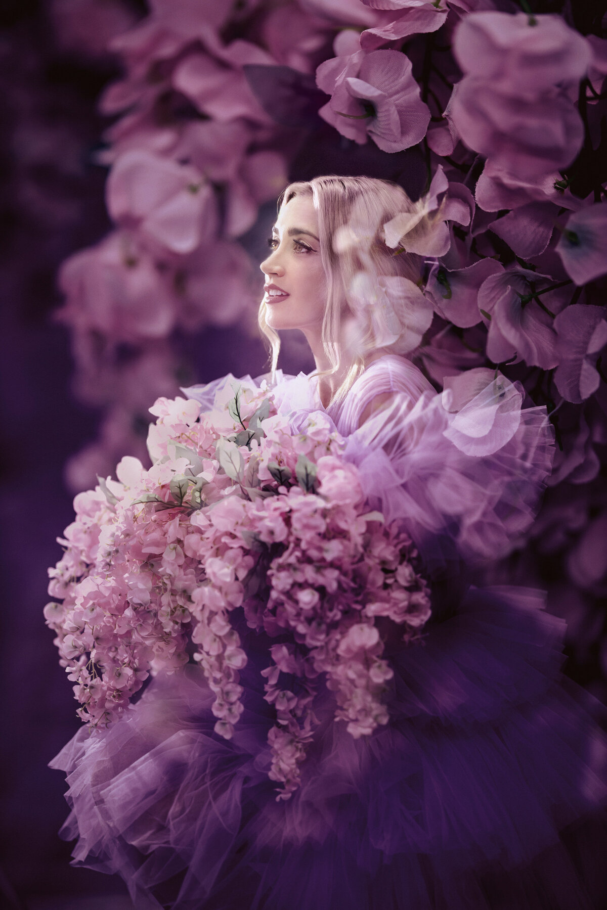 A woman with purple flowers all around her.