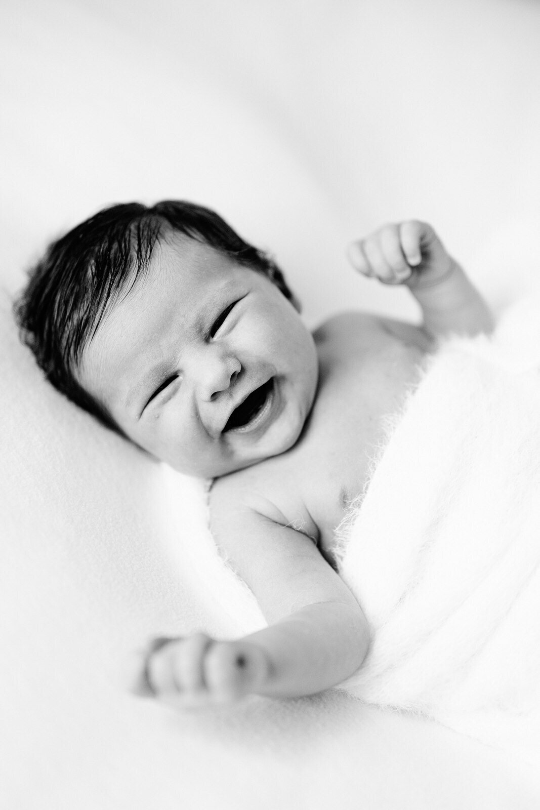 Smiling baby wrapped in white