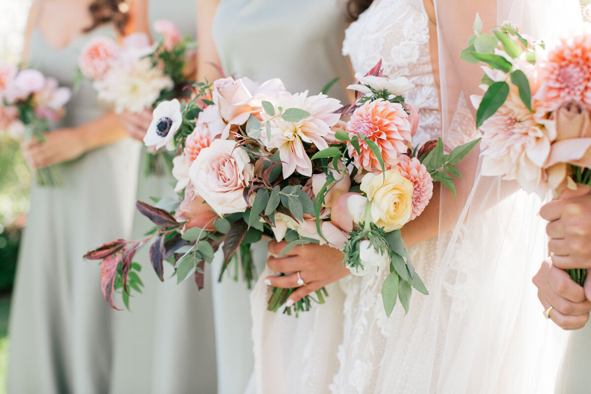 bridesmaids holding colorful bouquets by Wild Dahlia Florals
