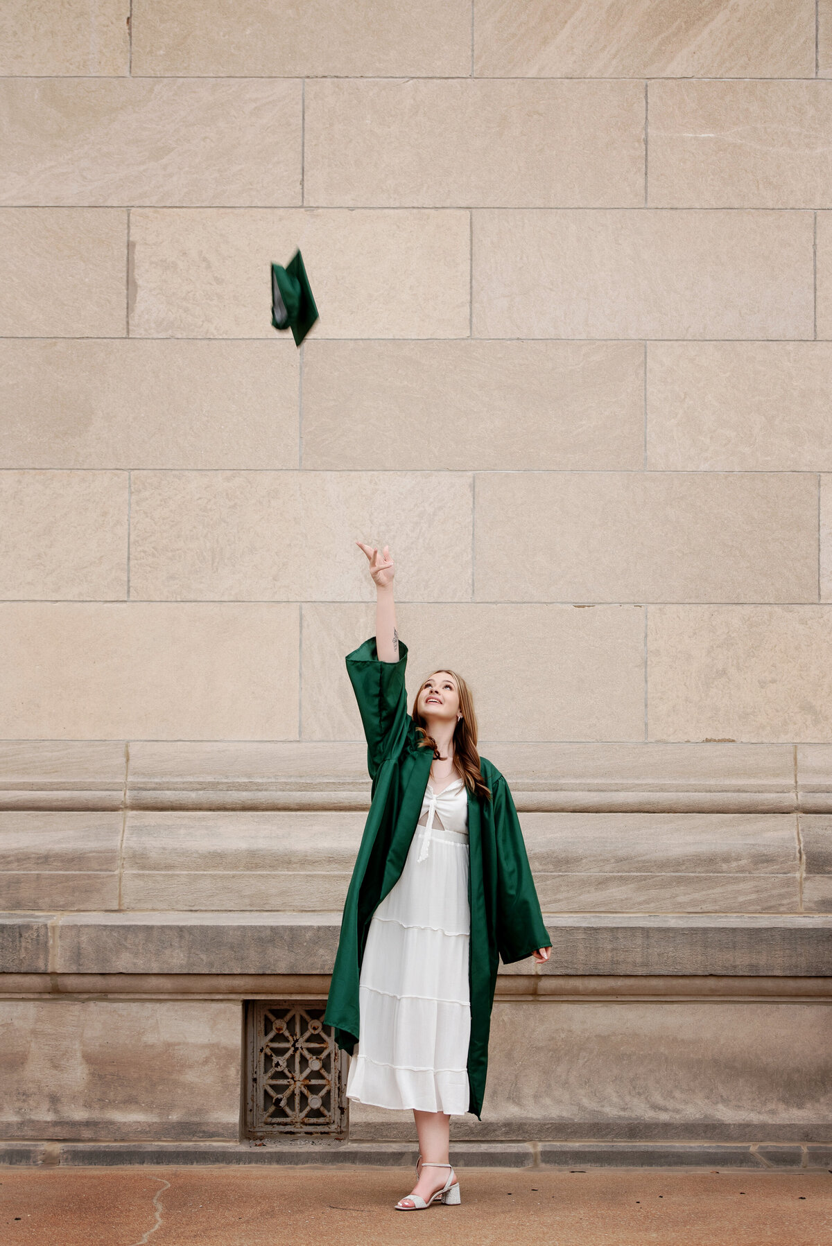 st-louis-senior-photographer-teen-girl-in-lindburgh-high-school-cap-and-gown-tossing-cap