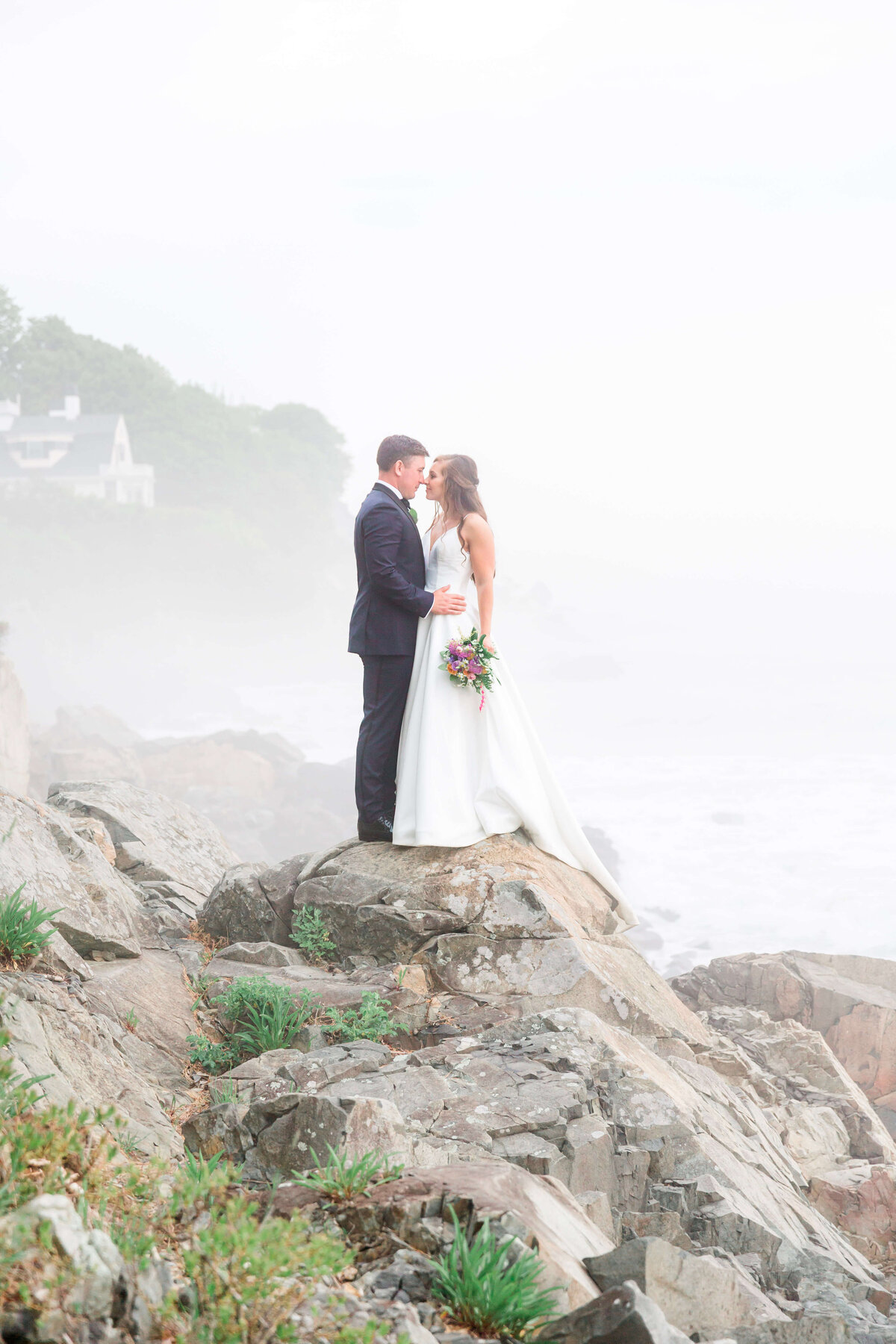 adventurous bride and groom standing on rocks at York Harbor beach for york Inn Wedding  (7)