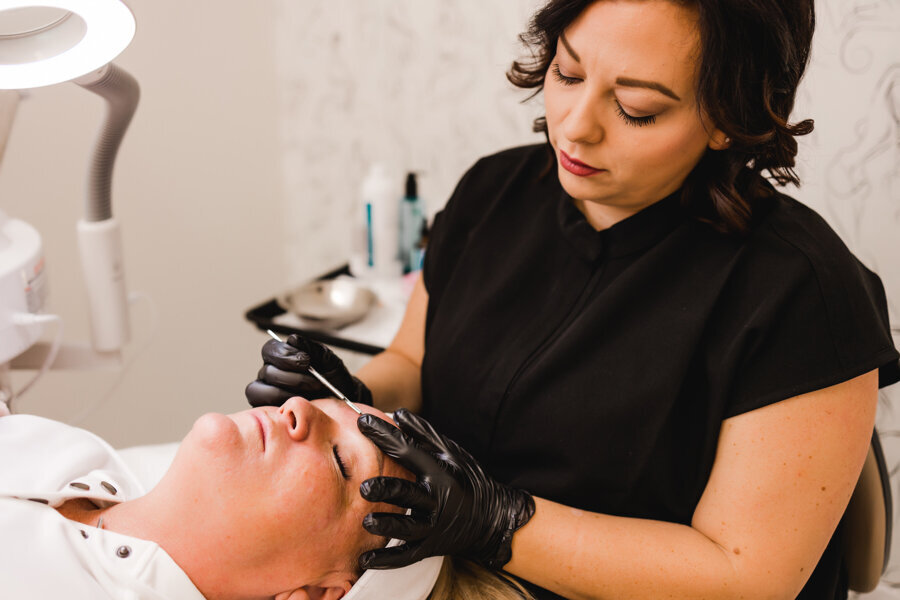 esthetician working on a woman's face