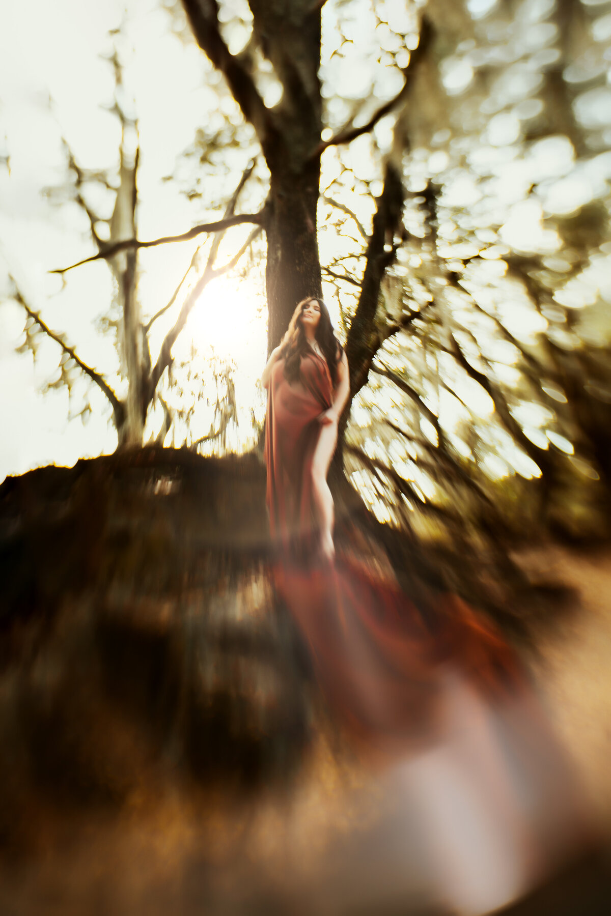 hippie woodland fairytale pregnancy photos of a woman standing on  giant tree roots
