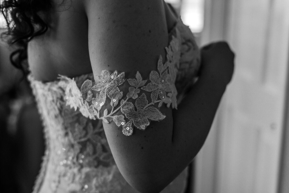 Black and white close-up of the bride’s lace wedding dress sleeve detail during the getting ready moments at Lesner Inn.