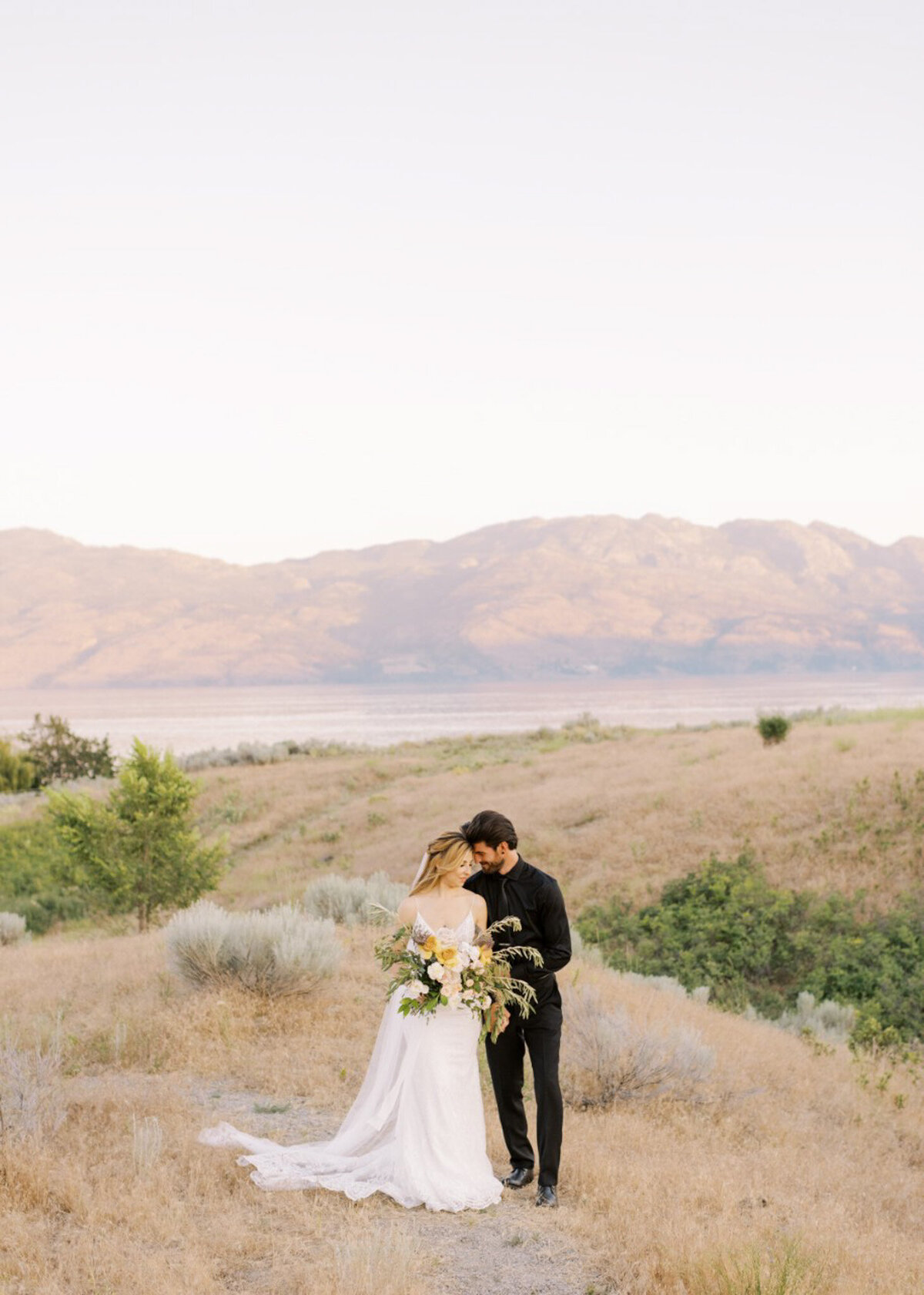 Romantic portrait of bride and groom in the mountains captured by Minted Photography, fine art and romantic wedding photographer in Okanagan, BC. Featured on the Bronte Bride Vendor Guide.