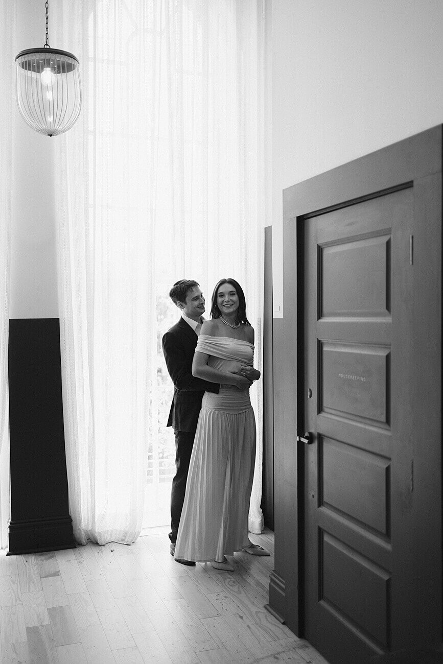 black and white photo of guy holding girl from behind in Hotel Peter and Paul hallway