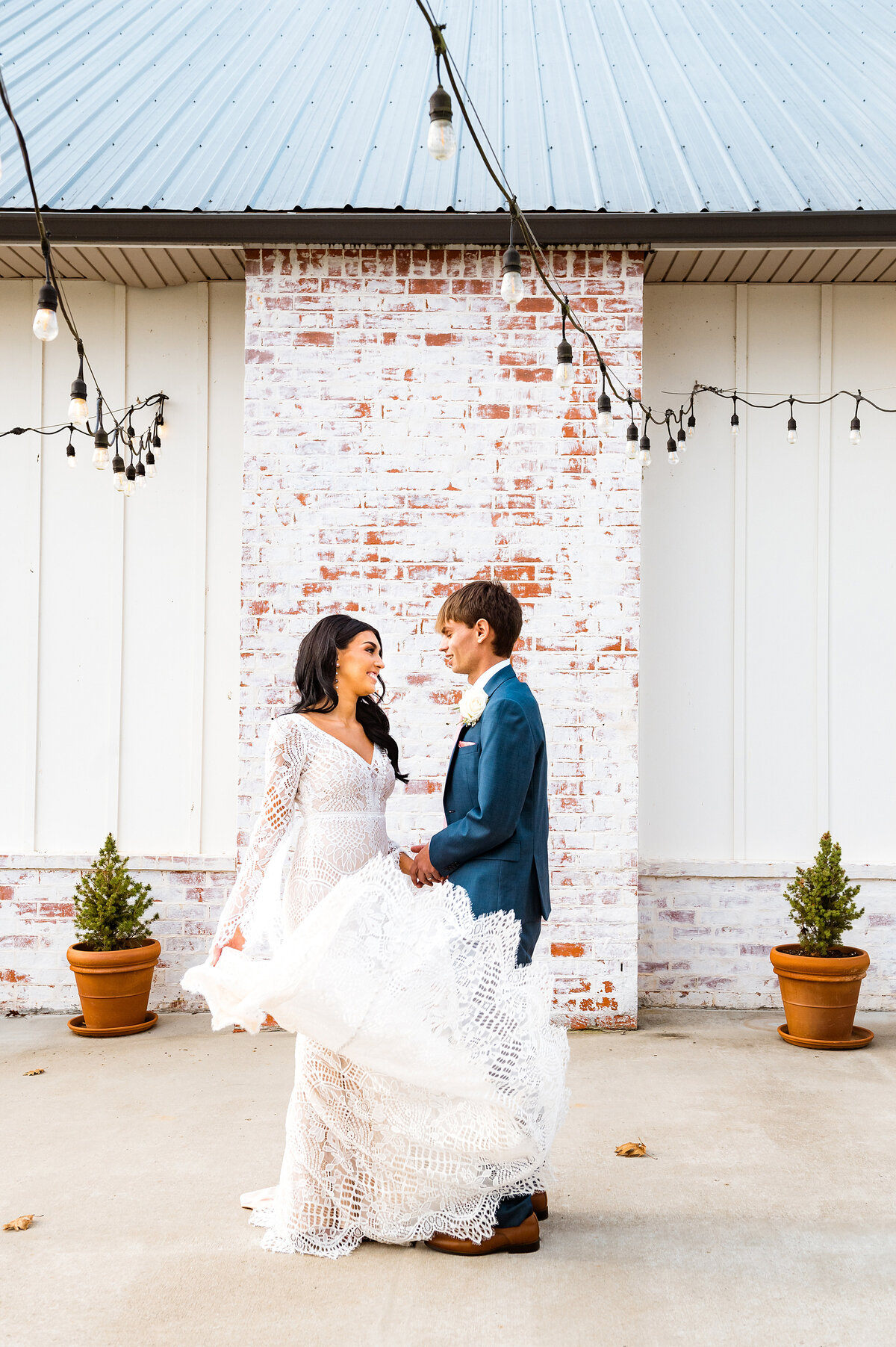 Bride twirling wedding dress while smiling at groom