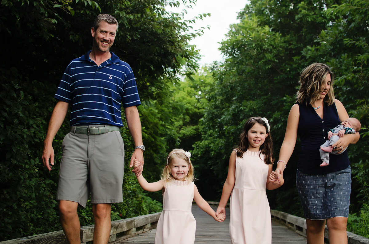 Portrait of a family of five walking on a wooden path taken at a country club in Northern Virginia by Sarah Alice Photography