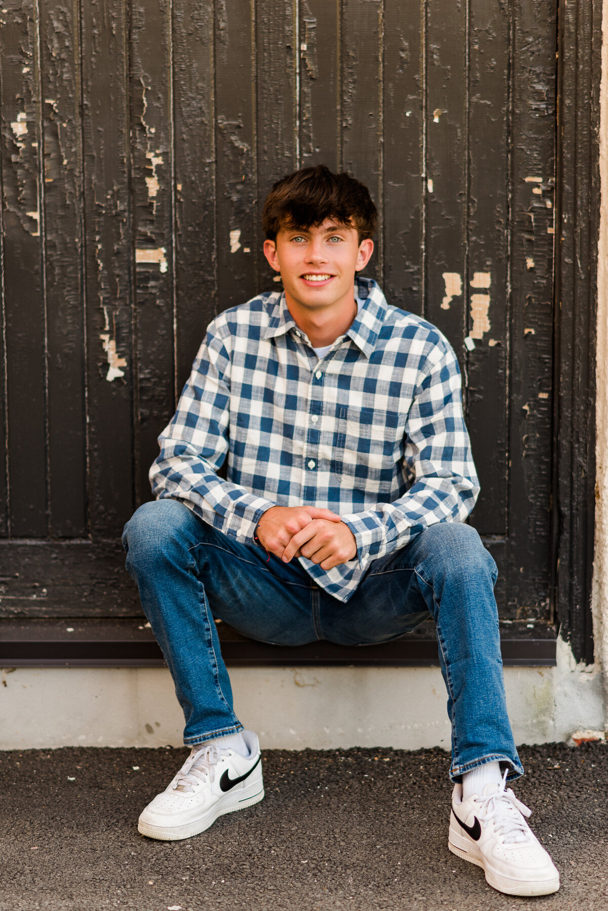 blue checked shirt white nike senior guy sits-8641