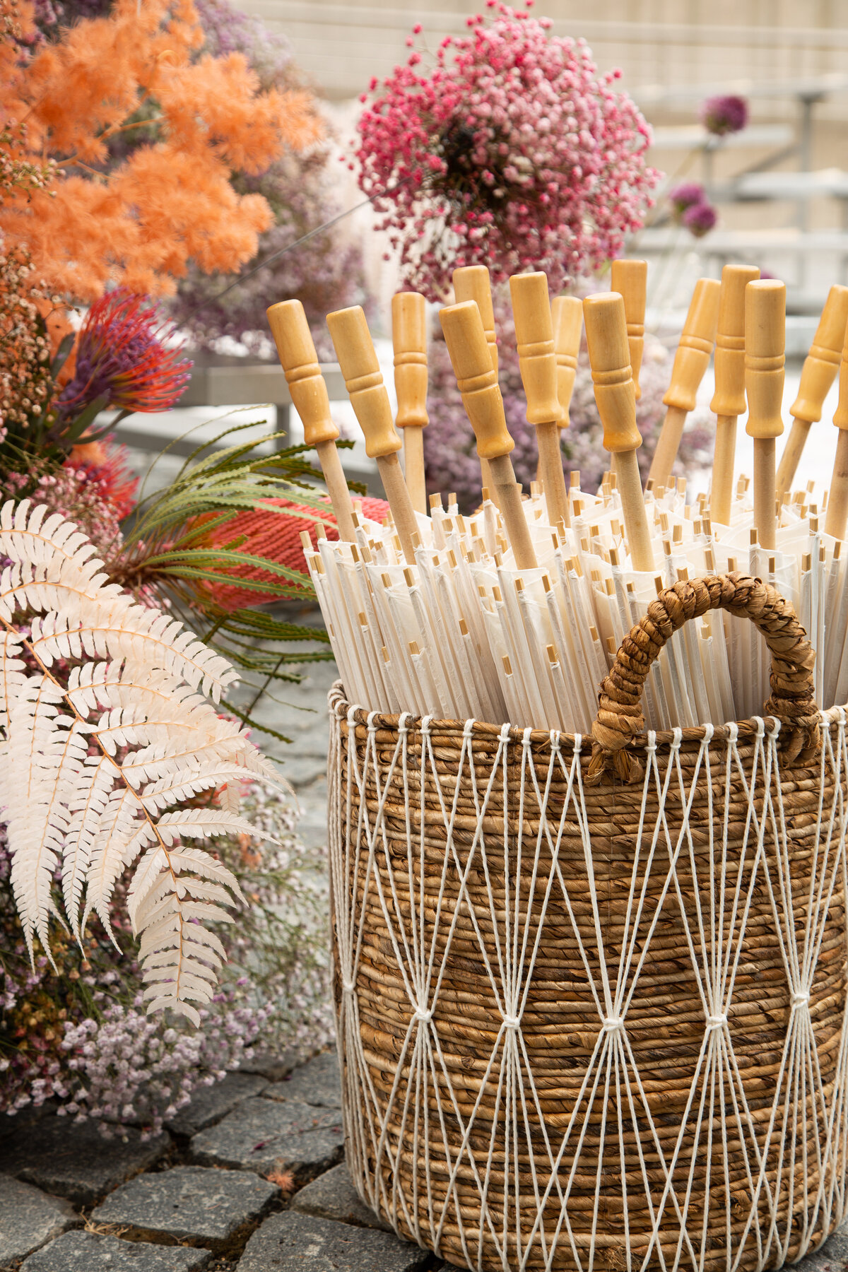 Basket of umbrellas and floral details at estate wedding